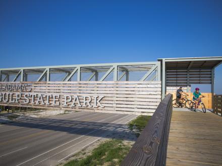 bikers going across the Gulf State Park pedestrian bridge