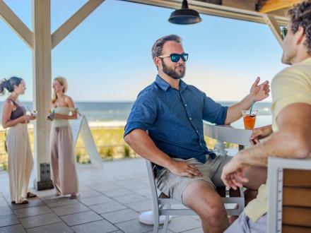 Friends sitting at the bar at Coastal beachfront restaurant in Orange Beach