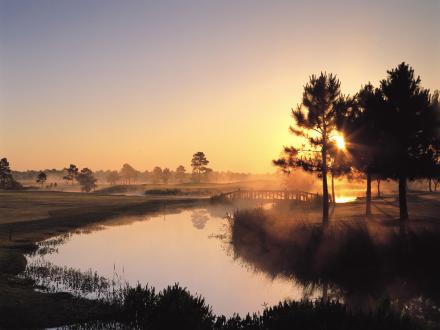 Scenic view of the sun rising over water features on the Cypress Bend course at Craft Farms Golf Resort