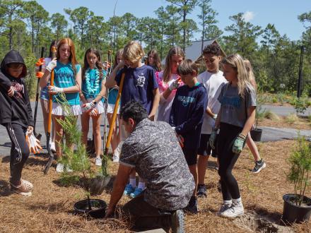 Worker of the eco-center teaching visitors about different vegetation on the campus