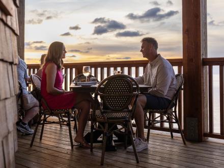 Couple dining on the outdoor deck at Jesse's on the Bay fine dining restaurant in Fort Morgan