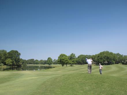 Two men golfing at the Arnold Palmer designed course at Craft Farms Golf Resort in Gulf Shores