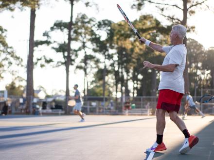 Snowbird playing tennis at the public courts in Gulf Shores