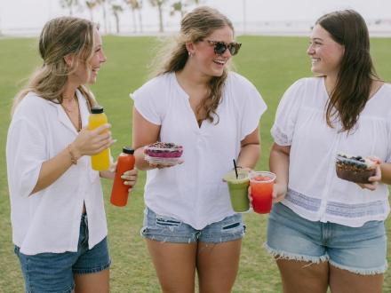 Girls with juices, smoothies, and acai bowls from Fruitful in Gulf Shores