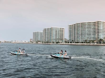 Family jet skiing in the bay in front of The Caribe waterfront resort in Orange Beach