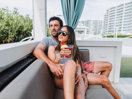 Couple lounging in a private cabana at the lazy river at The Caribe Bayfront resort in Orange Beach