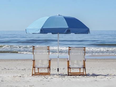 two beach chairs and an umbrella sitting in the sand near the water in Orange Beach