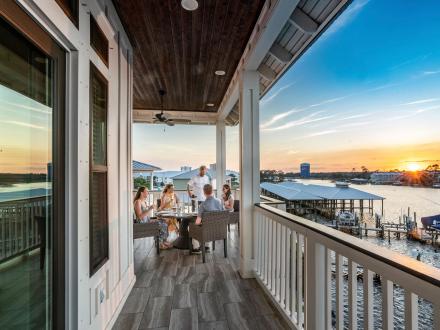 family dining on the deck overlooking the water in a vacation rental in orange beach