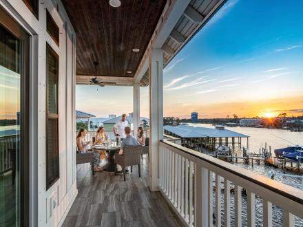 Family dining on their beach house balcony in Orange Beach