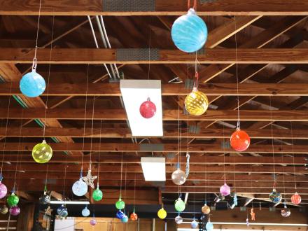 Handcrafted glass ornaments hanging from the ceiling at The Hot Shop studio at The Coastal Arts Center in Orange Beach