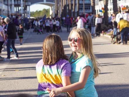 Kids smiling during the Kid and Pets Mardi Gras parade at The Wharf in Orange Beach