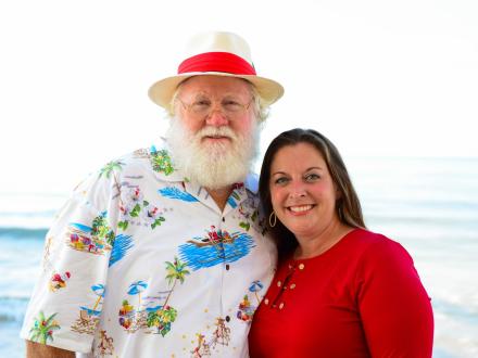 Woman posing with a coastal Santa on the beach in Gulf Shores