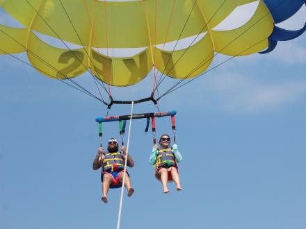 Couple parasailing with Ike's above the beach in Gulf Shores