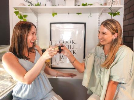 Friends clinking wine glasses at Lauria's by the Beach coastal bar in Gulf Shores