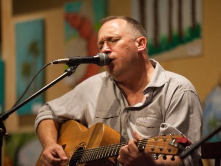Man performing live music at Ginny Lane's seafood restaurant in Orange Beach