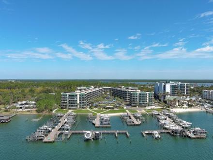 Aerial view of piers and boat docks at Phoenix on the Bay waterfront resort in Orange Beach