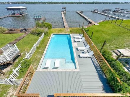Balcony view of private pool and boat dock at Dock Holiday vacation home in Gulf Shores