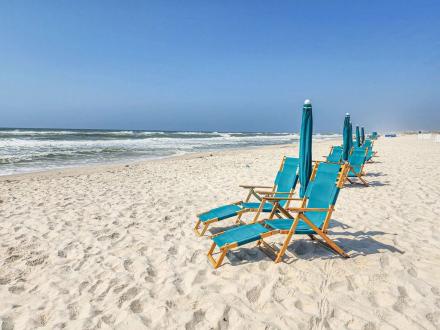 Beach chairs near the shore at Beach Club Resort in Fort Morgan