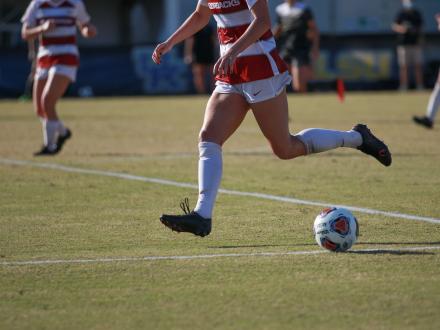 Soccer players running down the field at the SEC Women's Soccer Championship in Orange Beach
