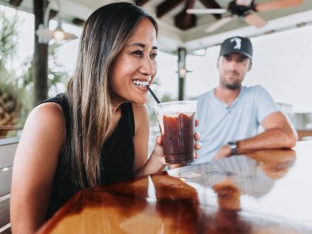 woman sipping a bushwacker cocktail at Shipp's Upper Deck seafood restaurant in Orange Beach