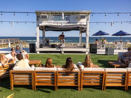people enjoying live music at coastal beachfront restaurant in orange beach