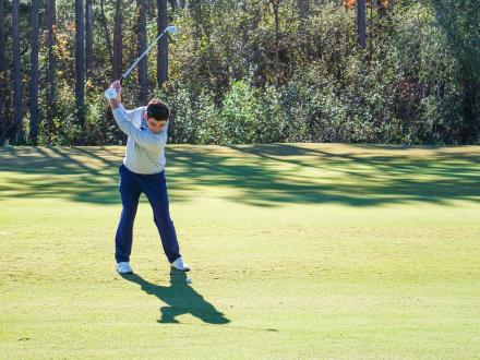 golfer swinging his club on the course