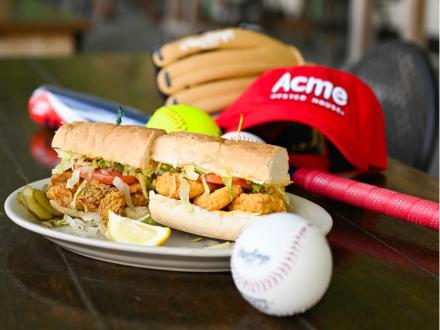 Poboy and baseball gear on the table at ACME sports team friendly restaurant in Gulf Shores