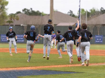 High school baseball team celebrating on field after a win in Gulf Shores