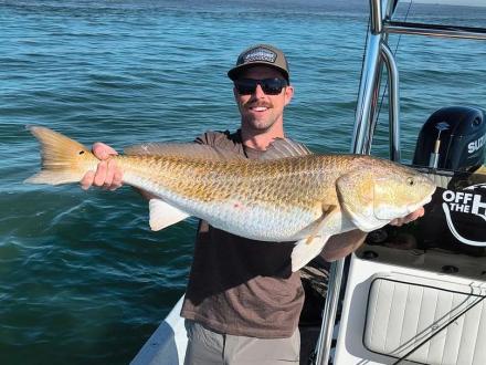 angler holding redfish while inshore fishing off the beach in Gulf Shores