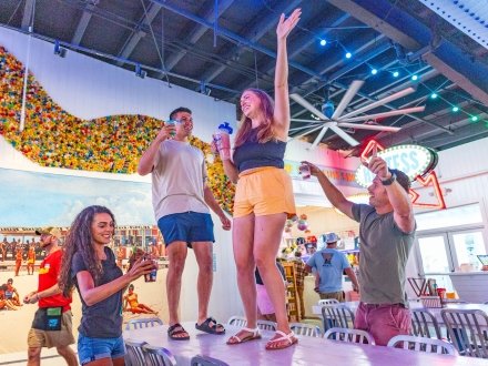 Friends dancing on the table at The Hangout beach restaurant in Gulf Shores