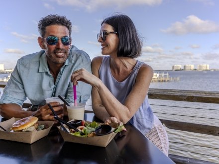 Couple enjoying some food and drinks while on a data on Alabama's Beaches