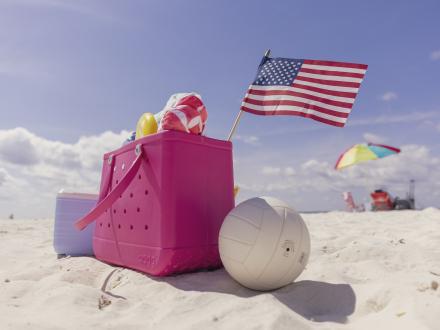 Beach bag sitting on the beach with a volleyball