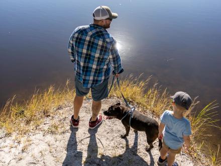 Dad and son walking dog at Luxury RV Resort in Gulf Shores