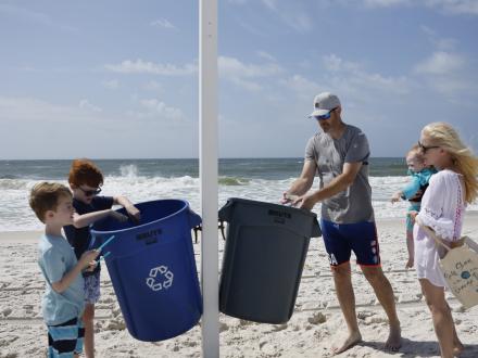 A family recycling on Alabama's Beaches