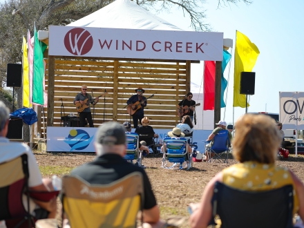 attendees listening to live local music from the stage at ballyhoo festival in gulf shores
