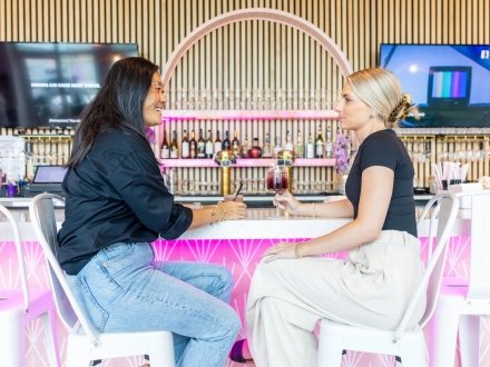 Girlfriends sitting at the bar at Gulf Babe Wine Boutique at The Wharf in Orange Beach