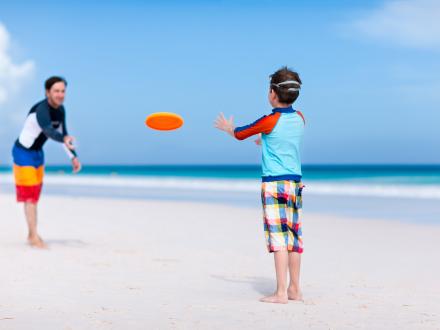 Kids throwing a frisbee on the beach