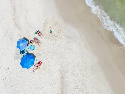 aerial view of family relaxing by the water on the beach in Orange Beach