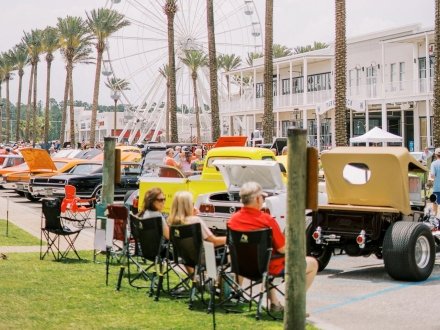 People sitting in lawn chairs admiring the classic cars at the Bama Coast Cruisin' car show in Orange Beach