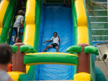 Kid sliding down an inflatable slide in the Kid's Zone at the Orange Beach Seafood Fest at The Wharf