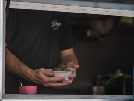 Food truck vendor handing over a bowl of fresh seafood 