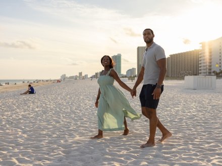 couple holding hands on the beach at sunset