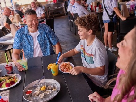 Family eating fresh seafood at Sea-N-Suds local beach restaurant in Gulf Shores