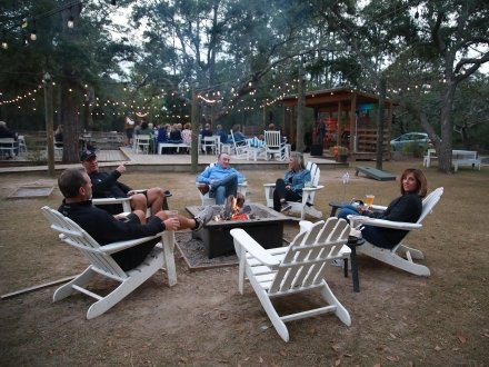 people dining around a fire pit Woodside Restaurant in Gulf State Park