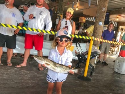 Young girl holding a fish caught during the Flora-Bama Fishing Rodeo family fishing tournament in Orange Beach