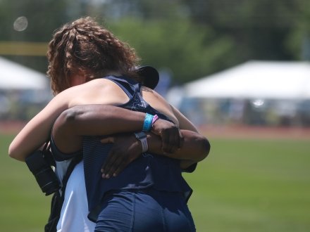 A player and coach hugging during awards at the AHSSA State Track & Field Championships on Alabama's Beaches