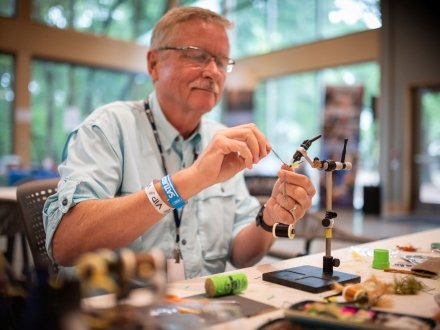 Angler demonstrating fly fishing tying at the Gulf Coast Classic Fly Fishing Tournament in Gulf Shores