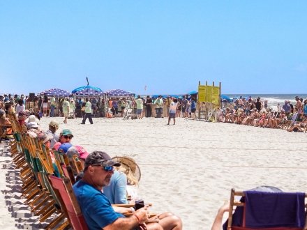 Crowd watching the mullet toss competition on the beach at Flora-Bama