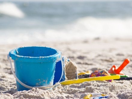 Beach toys laying on the sand by the shore