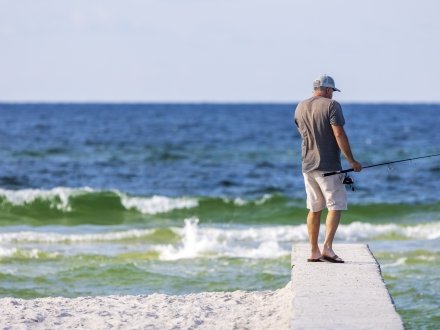 Angler fishing into the Gulf at Little Lagoon Pass in Gulf Shores fishing spot